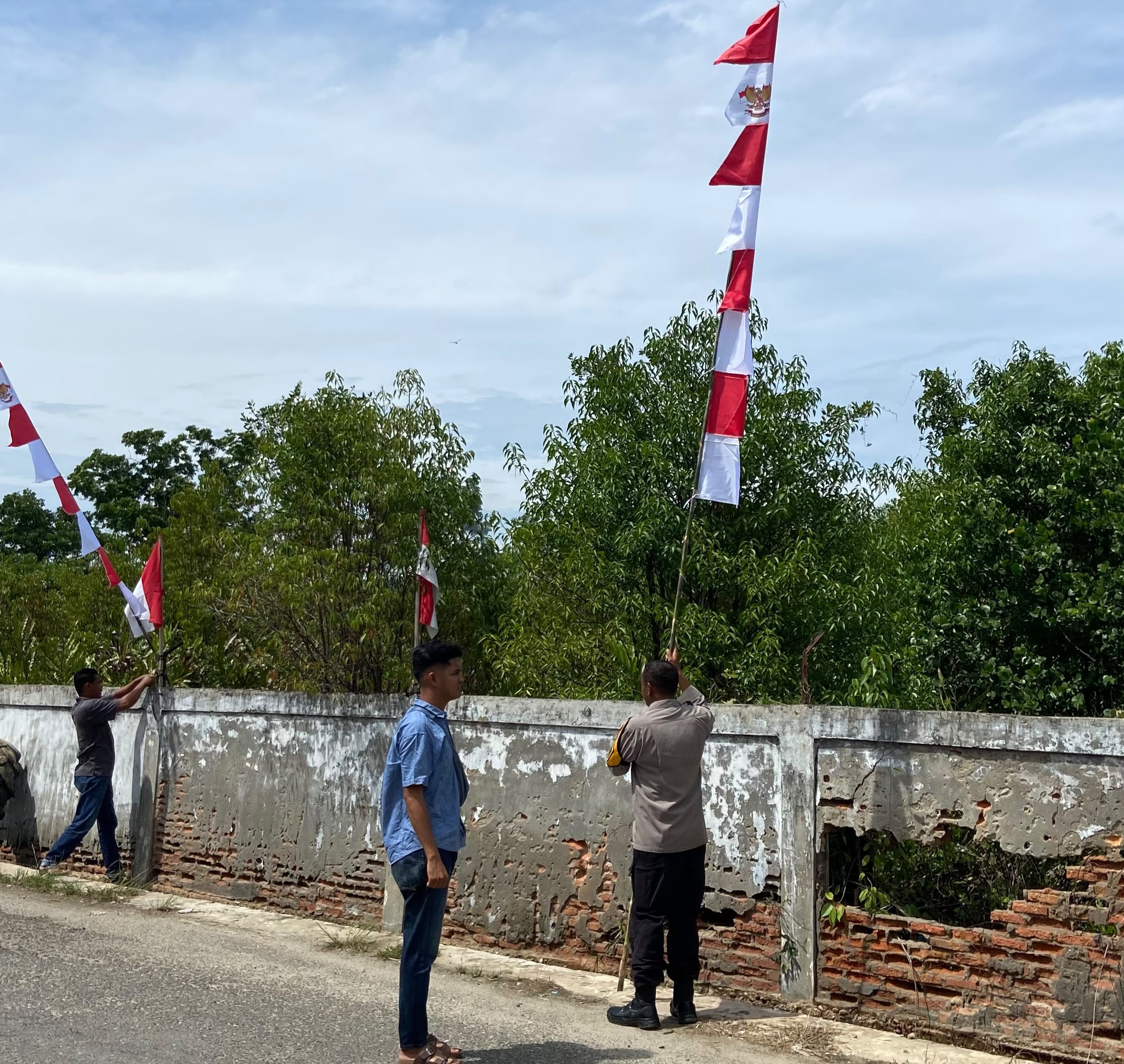 Semangat Kemerdekaan Menggelora, Bhabinkamtibmas Heriyanto Bersama Babinsa dan Perangkat Gampong Sungai Pauh Kibarkan Merah Putih